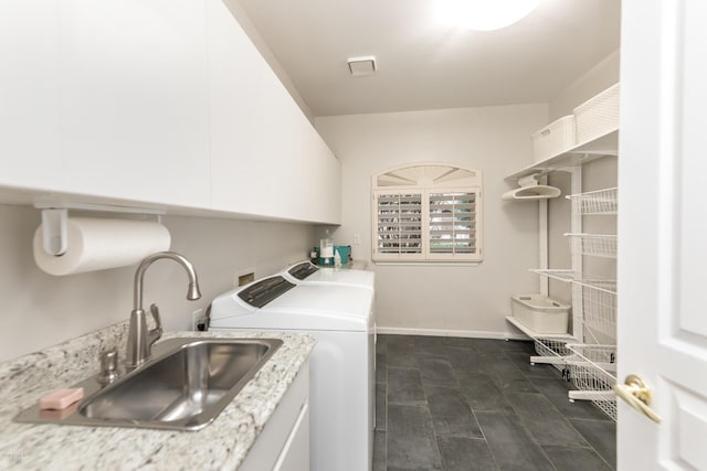 laundry room featuring cabinet space, separate washer and dryer, baseboards, and a sink