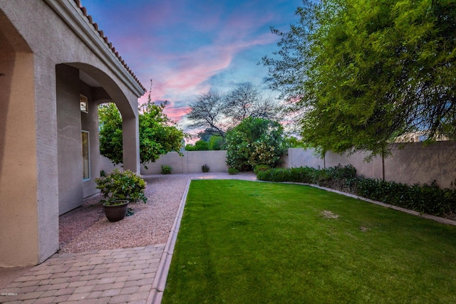 yard at dusk with a fenced backyard