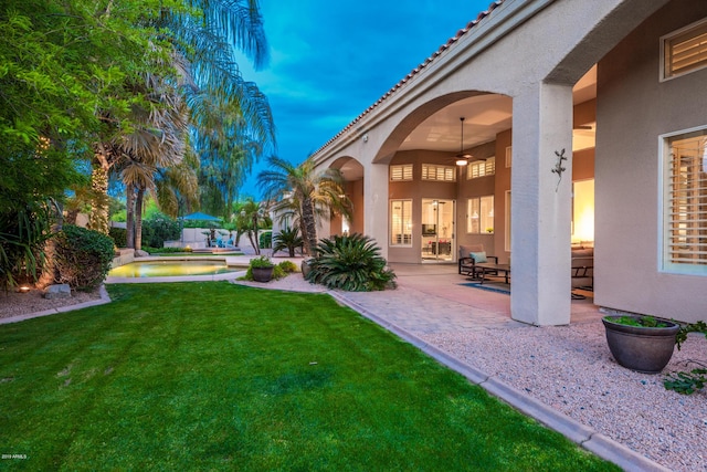 view of yard featuring a patio area, a fenced in pool, and a ceiling fan