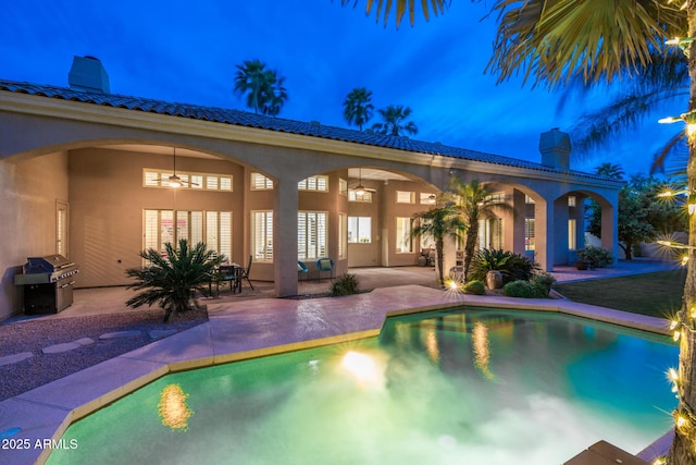 pool with grilling area, a patio, and a ceiling fan