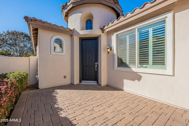 view of exterior entry with a patio