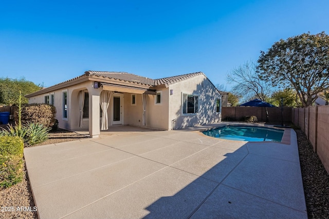 rear view of property with a fenced in pool, ceiling fan, and a patio area