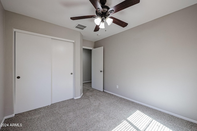 unfurnished bedroom with carpet, ceiling fan, and a closet