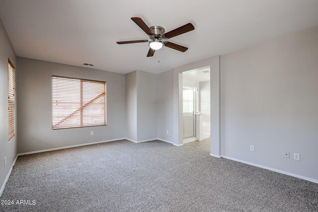 carpeted spare room featuring ceiling fan