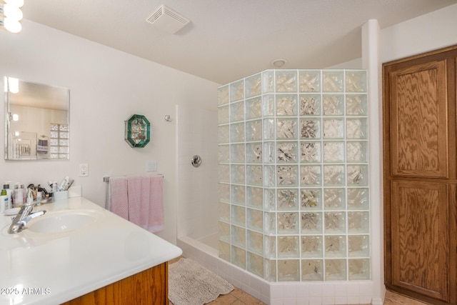 bathroom featuring vanity, walk in shower, visible vents, and tile patterned floors