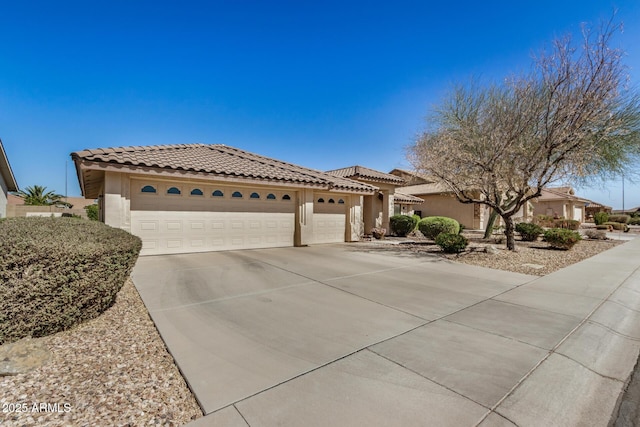 mediterranean / spanish home with driveway, a tiled roof, a garage, and stucco siding