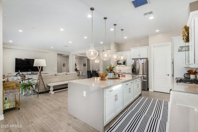 8772 W Brooklite Ln, Peoria, AZ 85383 - kitchen with stainless steel appliances, light wood-style flooring, white cabinetry, light countertops, and recessed lighting