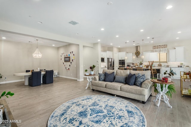 8772 W Brooklite Ln, Peoria, AZ 85383 - living area with light wood-type flooring, recessed lighting, baseboards, and a chandelier