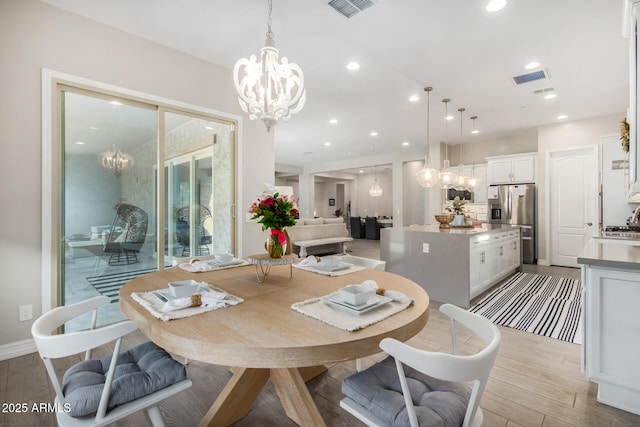 8772 W Brooklite Ln, Peoria, AZ 85383 - dining area featuring a chandelier, light wood-style floors, and recessed lighting