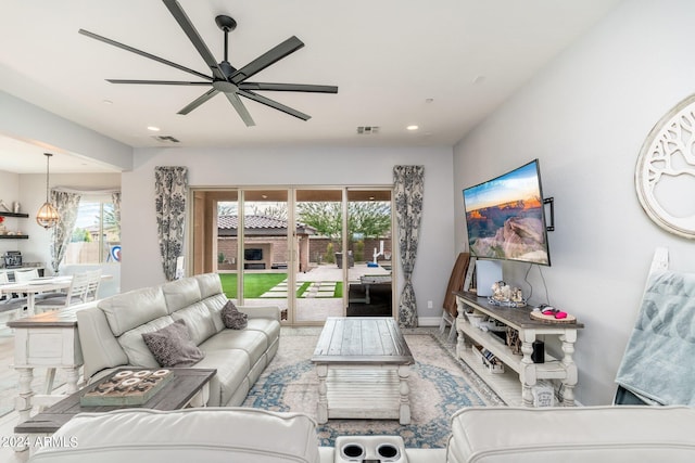 living room featuring ceiling fan with notable chandelier