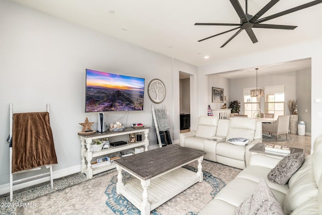 living room featuring ceiling fan with notable chandelier and light colored carpet