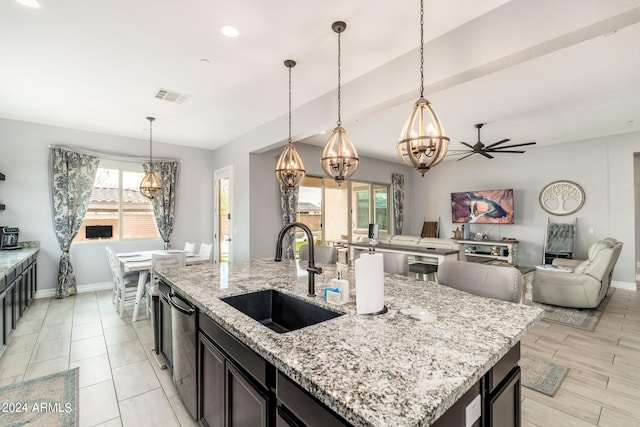 kitchen featuring pendant lighting, sink, an island with sink, and ceiling fan with notable chandelier