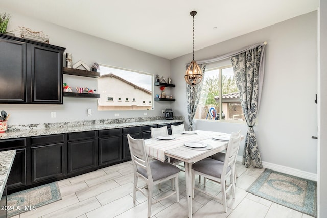 tiled dining room with a chandelier