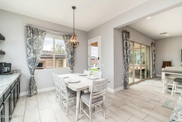 dining area featuring a chandelier and light tile flooring