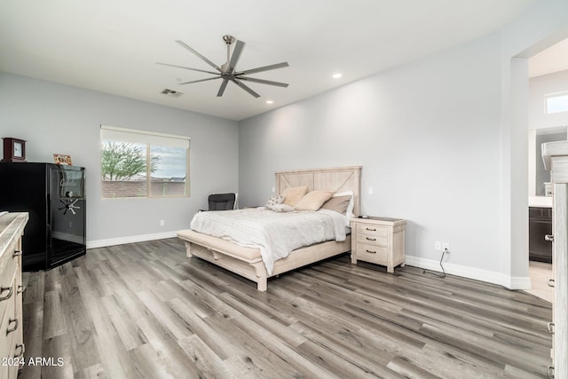 bedroom featuring hardwood / wood-style floors, connected bathroom, and ceiling fan