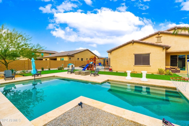 view of pool with a playground and a patio area