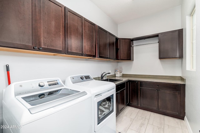 laundry area with washing machine and dryer, cabinets, sink, and light tile flooring