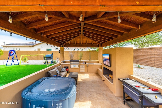 view of patio featuring a gazebo, a playground, and exterior kitchen