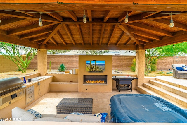 view of patio with a gazebo, grilling area, an outdoor living space with a fireplace, and an outdoor kitchen