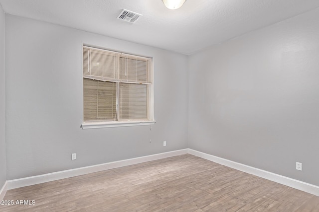 spare room featuring wood finished floors and baseboards