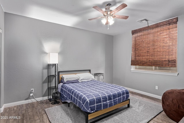 bedroom featuring wood finished floors, baseboards, and ceiling fan