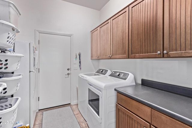 laundry area featuring cabinet space, washer and clothes dryer, and light tile patterned floors