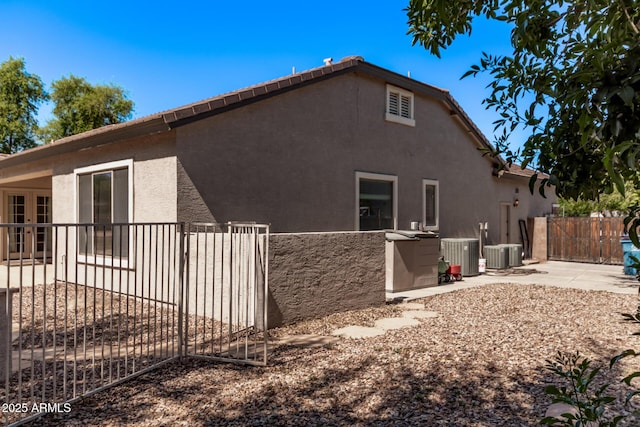 view of property exterior with fence, a patio area, stucco siding, and cooling unit