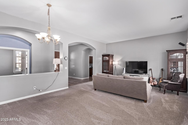 living area featuring arched walkways, carpet, a chandelier, and baseboards