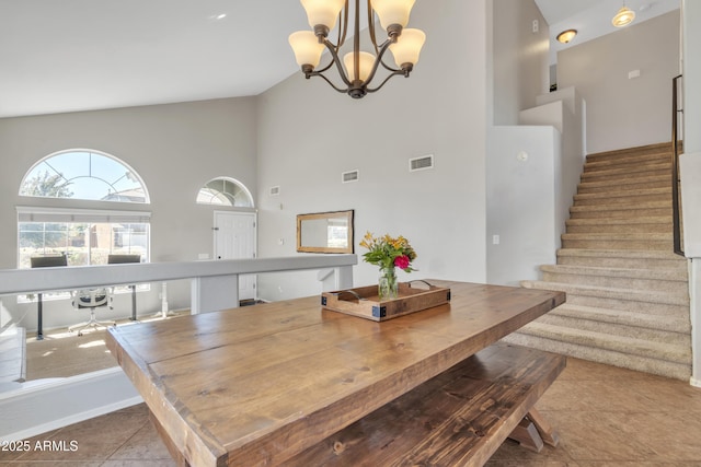 tiled dining space featuring stairway, visible vents, and high vaulted ceiling