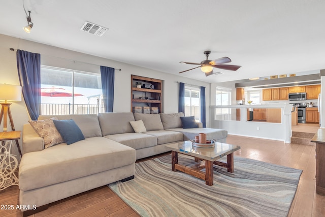 living room with a healthy amount of sunlight, light wood finished floors, and visible vents