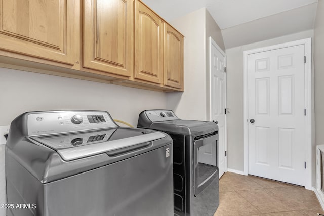 washroom with light tile patterned floors, independent washer and dryer, cabinet space, and baseboards