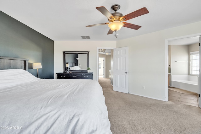 carpeted bedroom featuring ceiling fan, connected bathroom, visible vents, and baseboards