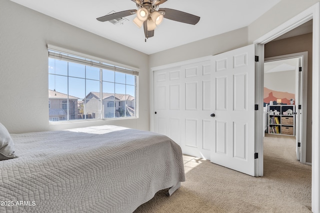 bedroom featuring ceiling fan, a closet, and light colored carpet