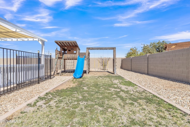 view of yard with a fenced backyard and a playground