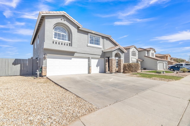 view of front of home with a garage, fence, a tiled roof, driveway, and stucco siding