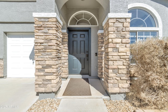 entrance to property with stone siding and an attached garage