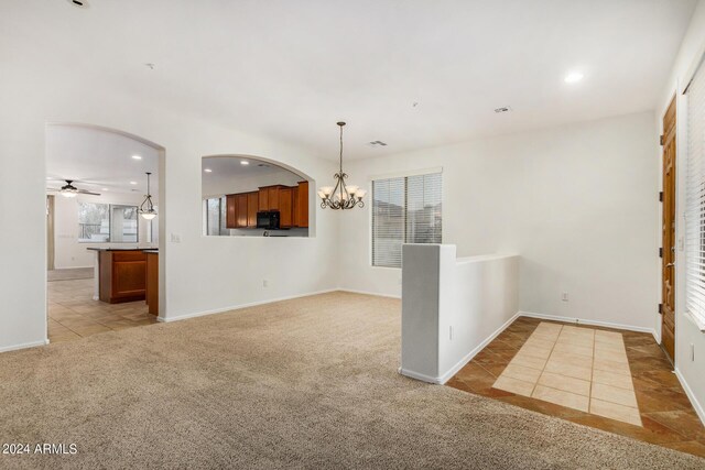 empty room featuring light colored carpet and a notable chandelier