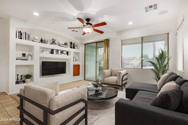 kitchen featuring a kitchen breakfast bar, ceiling fan with notable chandelier, black appliances, sink, and light tile patterned flooring