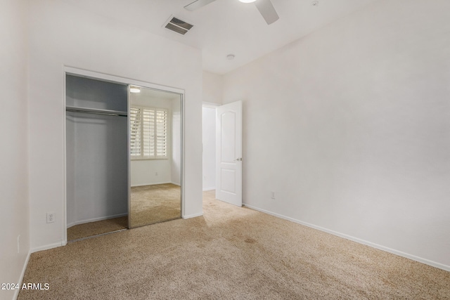 unfurnished bedroom featuring ceiling fan, a closet, and light carpet