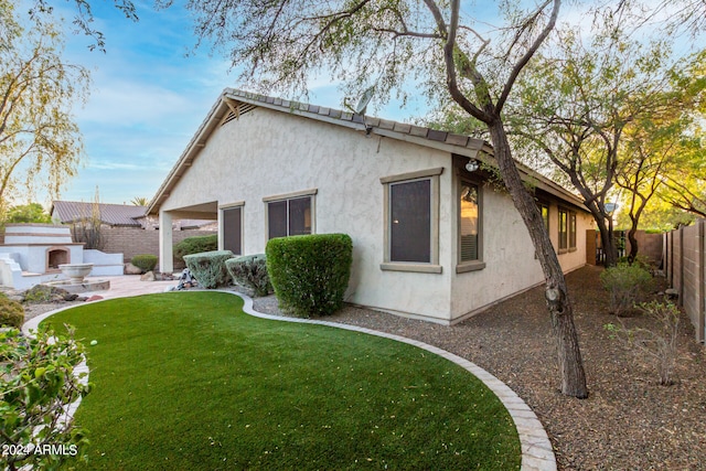 view of side of property featuring a lawn and a patio area