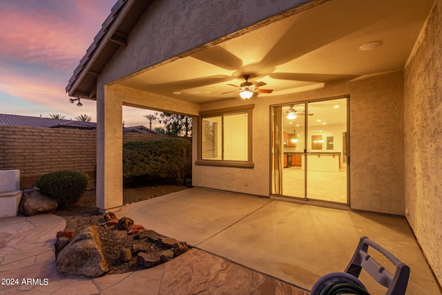 patio terrace at dusk featuring ceiling fan