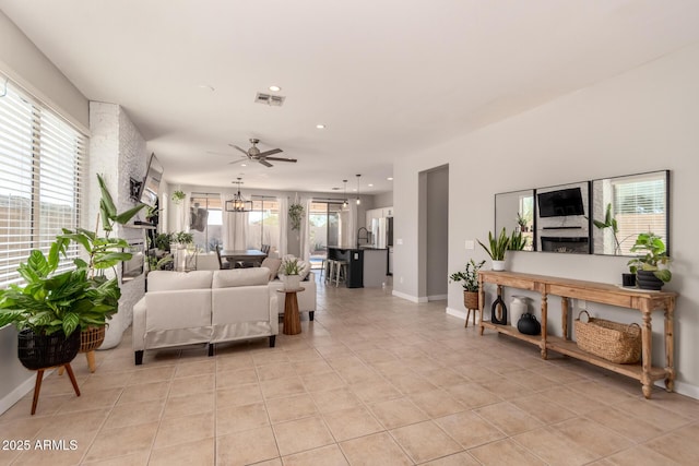 tiled living room with ceiling fan, a healthy amount of sunlight, and sink