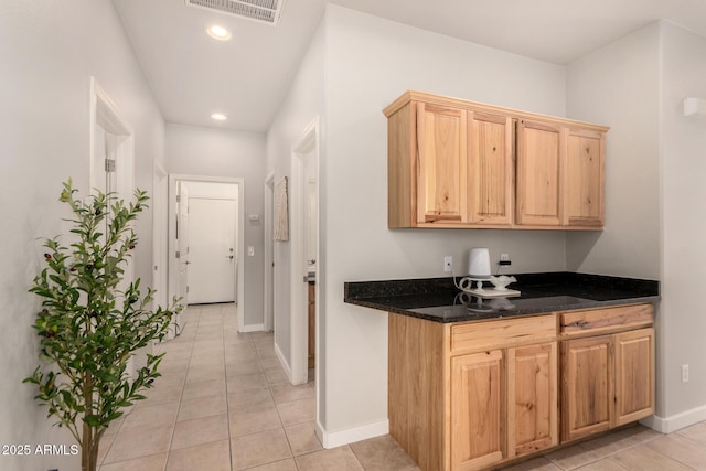 kitchen featuring light tile patterned flooring and dark stone countertops