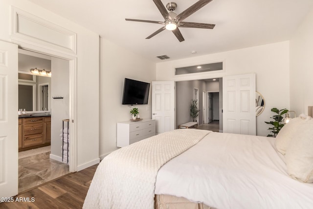 bedroom with connected bathroom, ceiling fan, and dark wood-type flooring