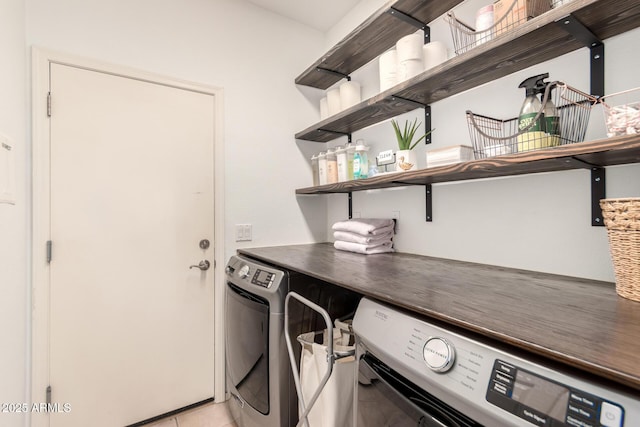 laundry room with light tile patterned floors and washing machine and dryer