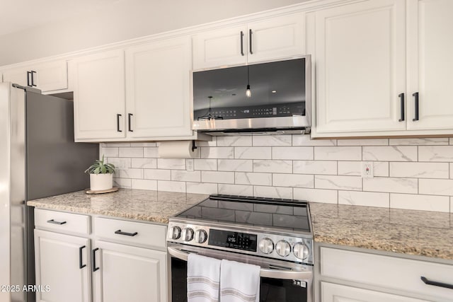 kitchen featuring light stone countertops, white cabinetry, backsplash, and appliances with stainless steel finishes