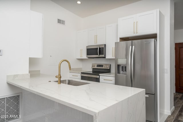 1351 N Pleasant Dr Unit 2011, Chandler, AZ 85225 - kitchen featuring appliances with stainless steel finishes, a peninsula, white cabinetry, light stone countertops, and recessed lighting