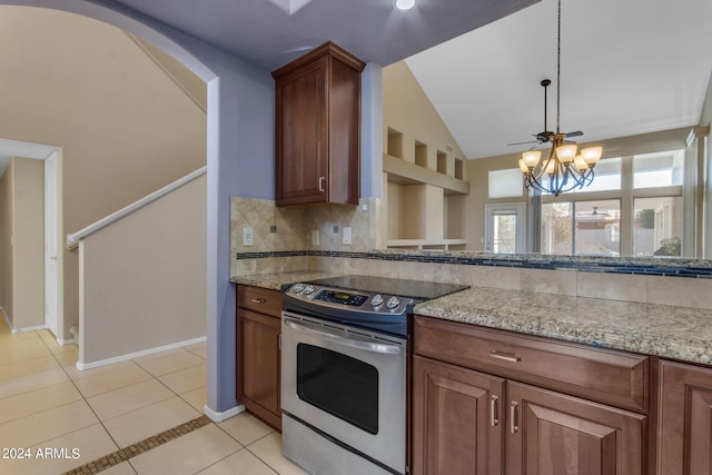 kitchen with stainless steel electric stove, vaulted ceiling, light stone counters, and a notable chandelier