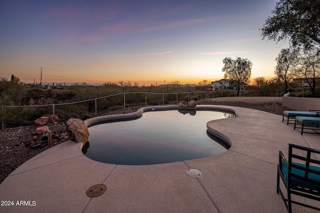 pool at dusk featuring a patio area