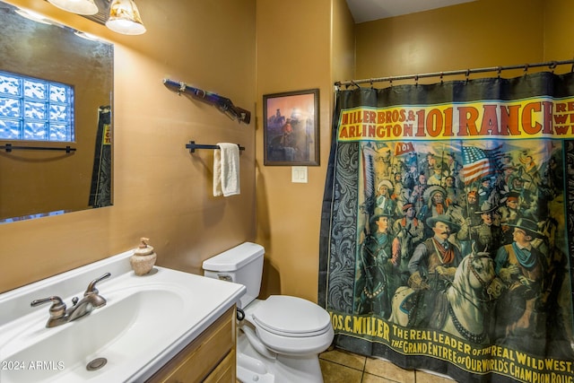 bathroom featuring toilet, tile flooring, and vanity